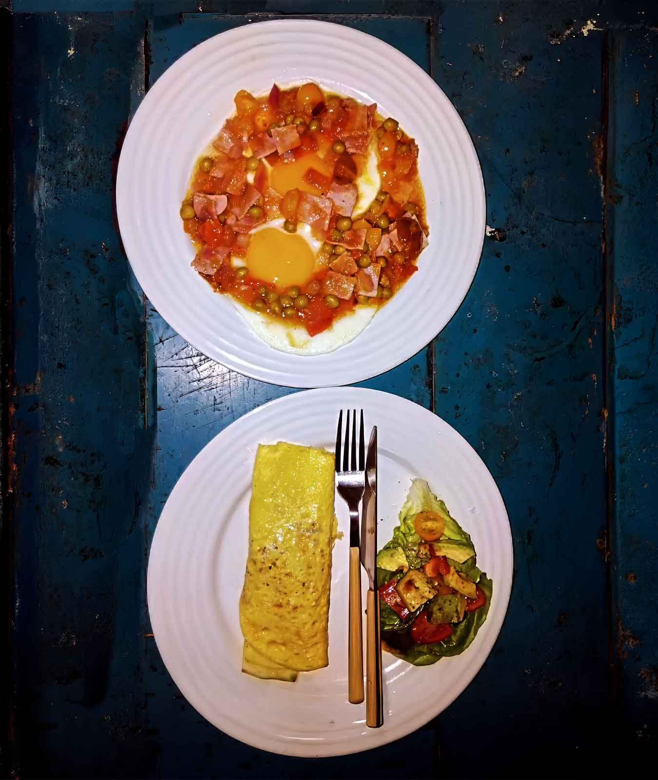 Breakfast Breakfast plates at Casa Bacab Café in Celestún, Yucatán, with eggs, omelet, and fresh vegetables.